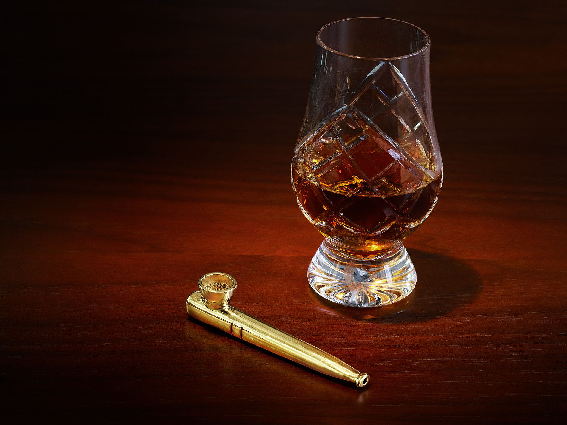 a fancy drink glass next to an heirloom pipe